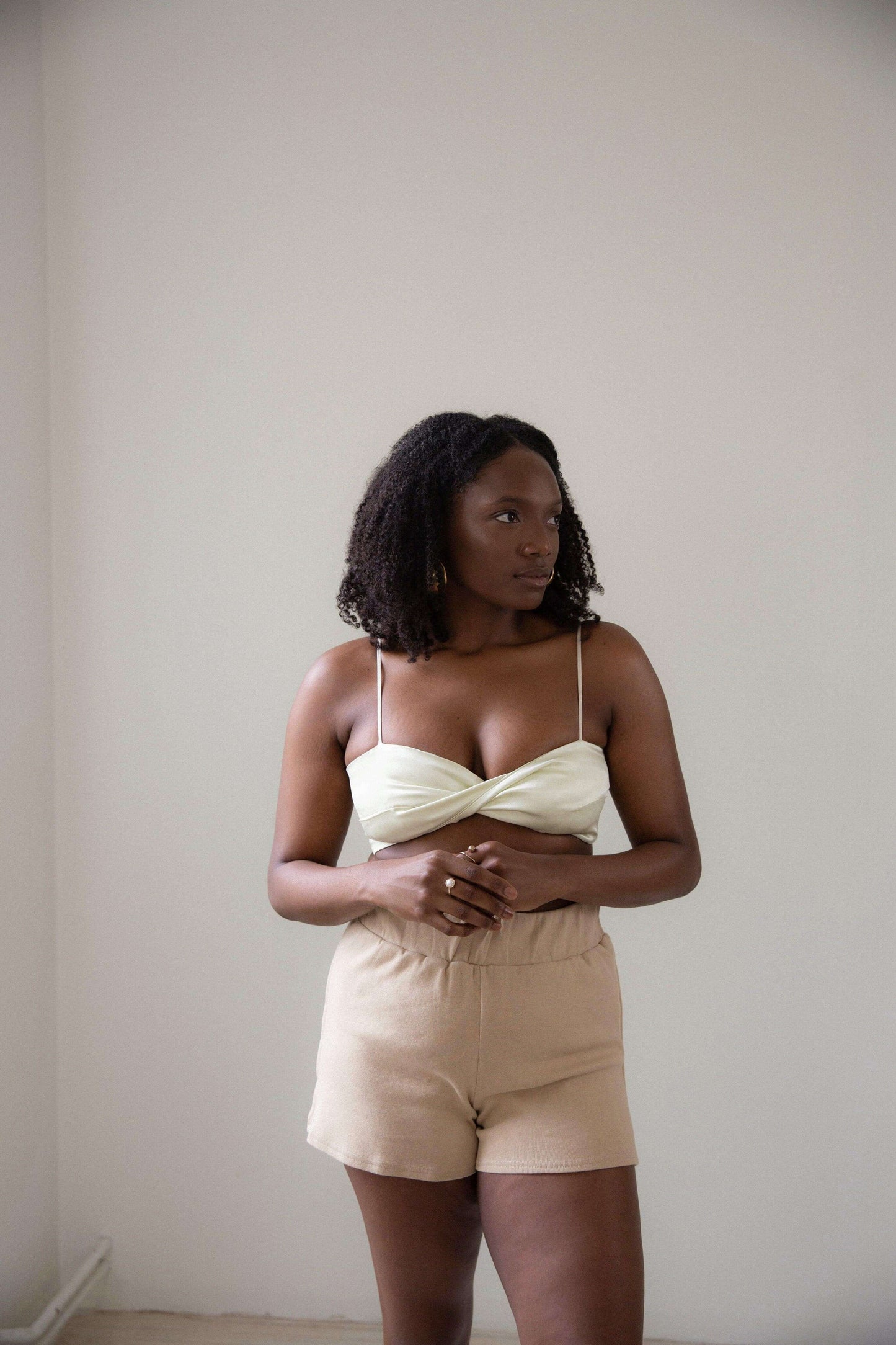 Front of model 2 wearing the Sienna Bandeau in yellow pearl colour, with Bomi knit short in Coffee Cream colour